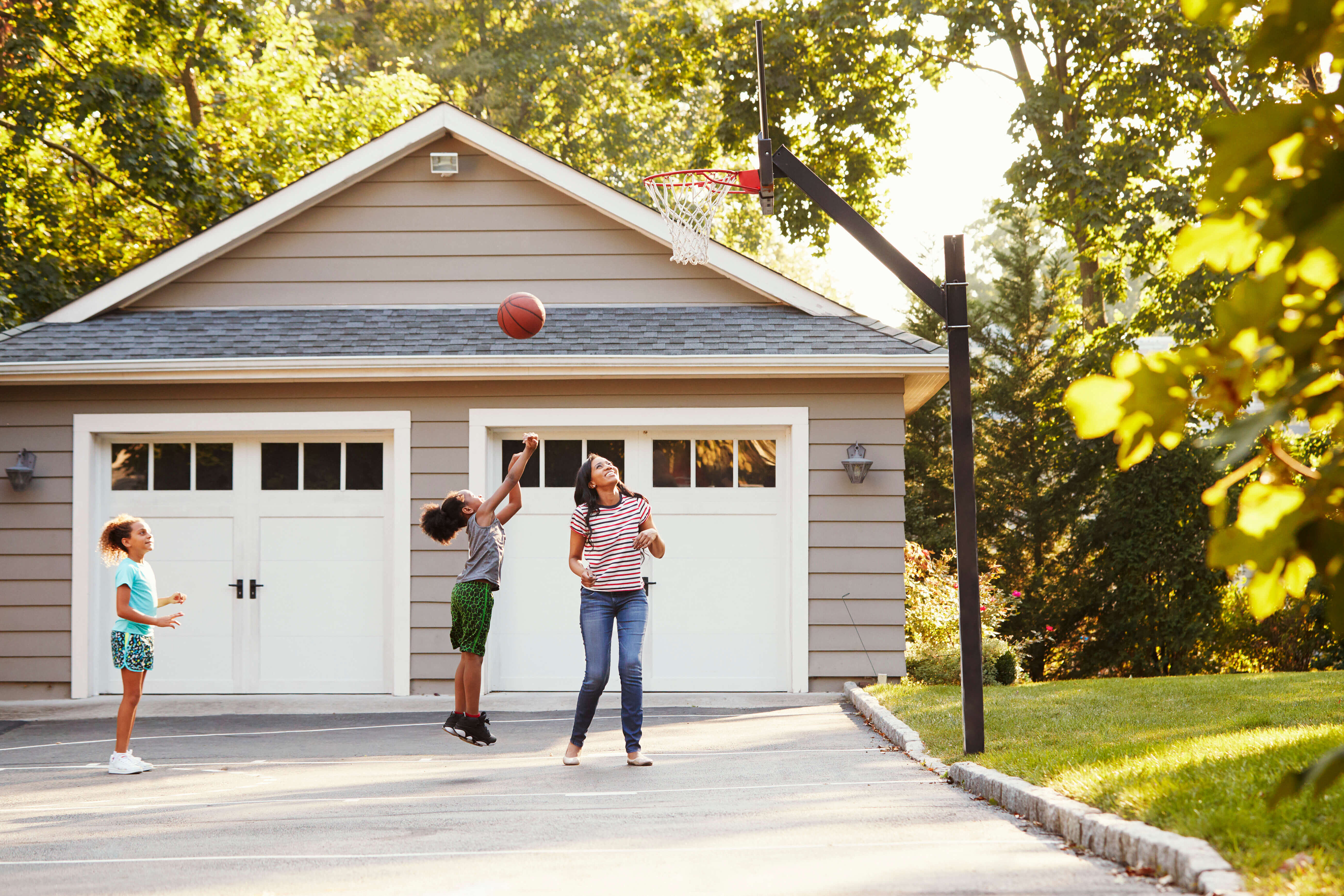 Family playing basketball in the driveway