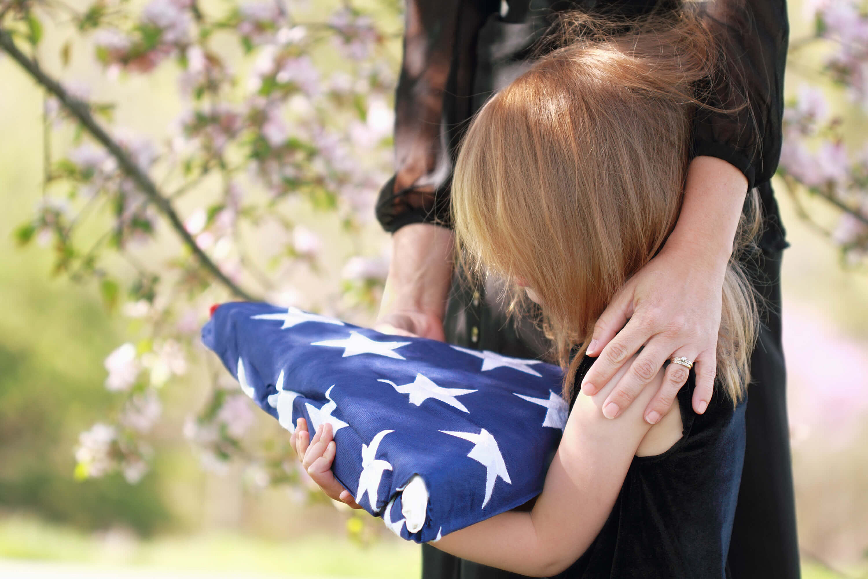 Little girl holding flag at memorial service