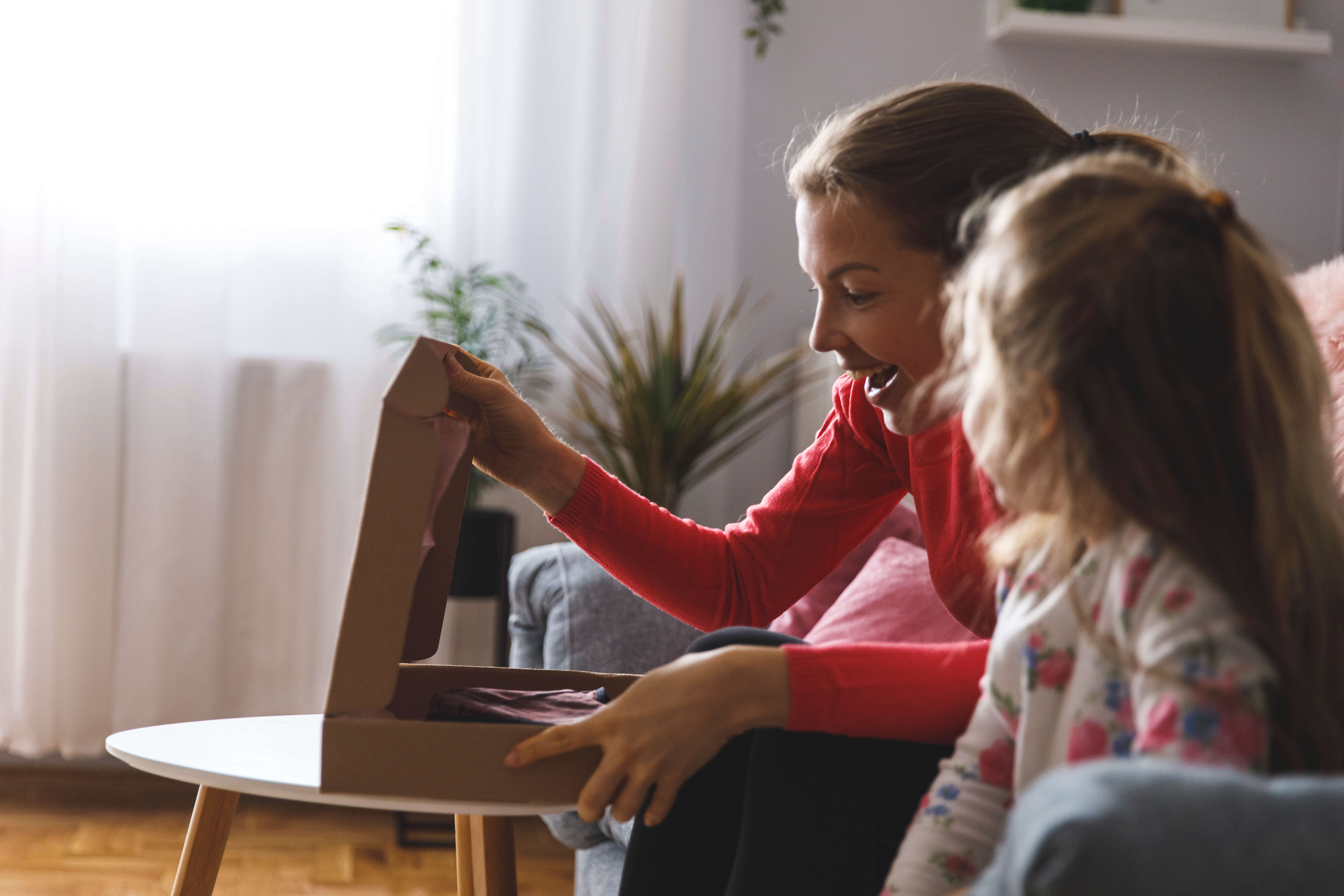 Mother and daughter opening box together