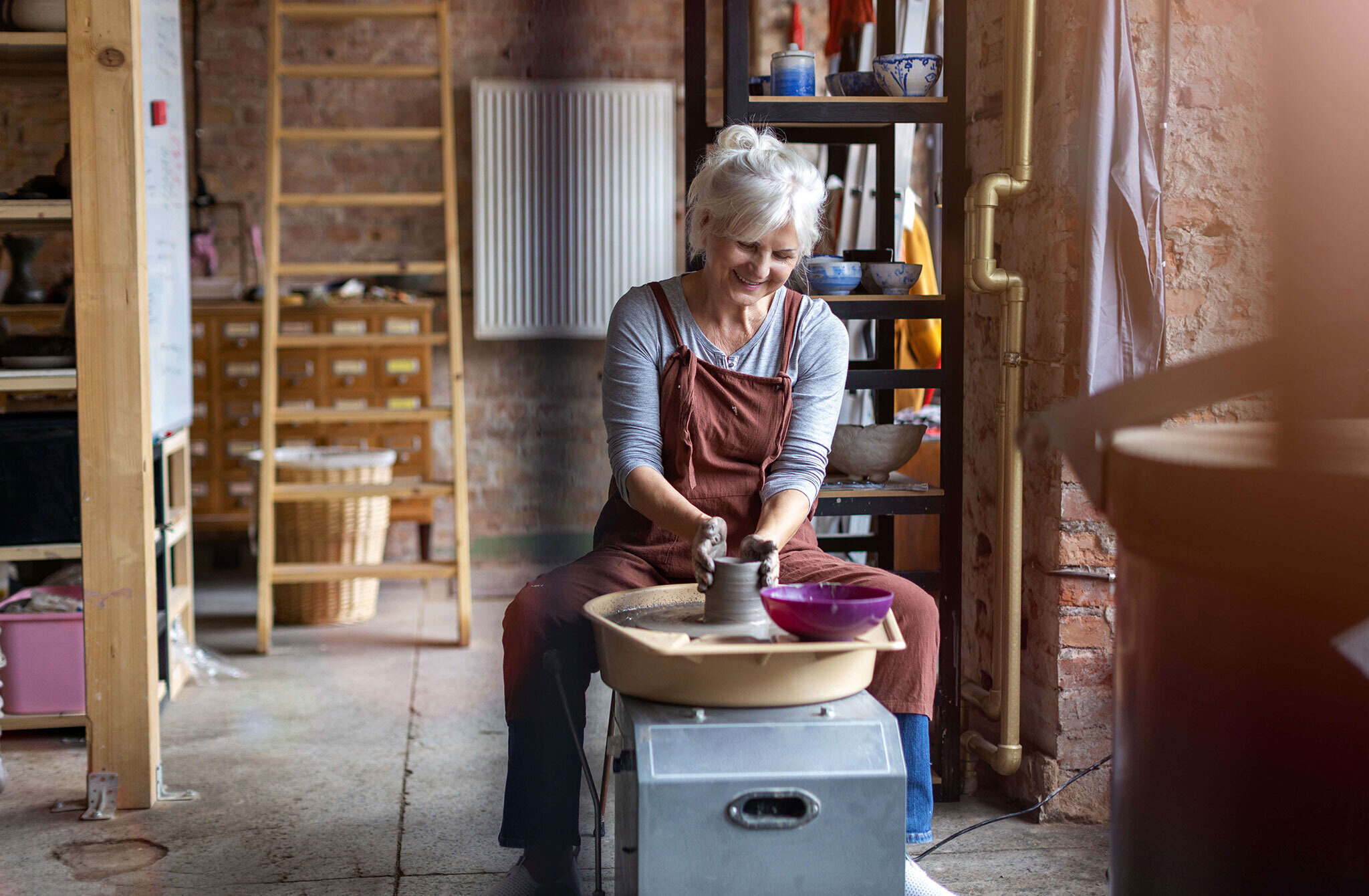 Older woman making pottery