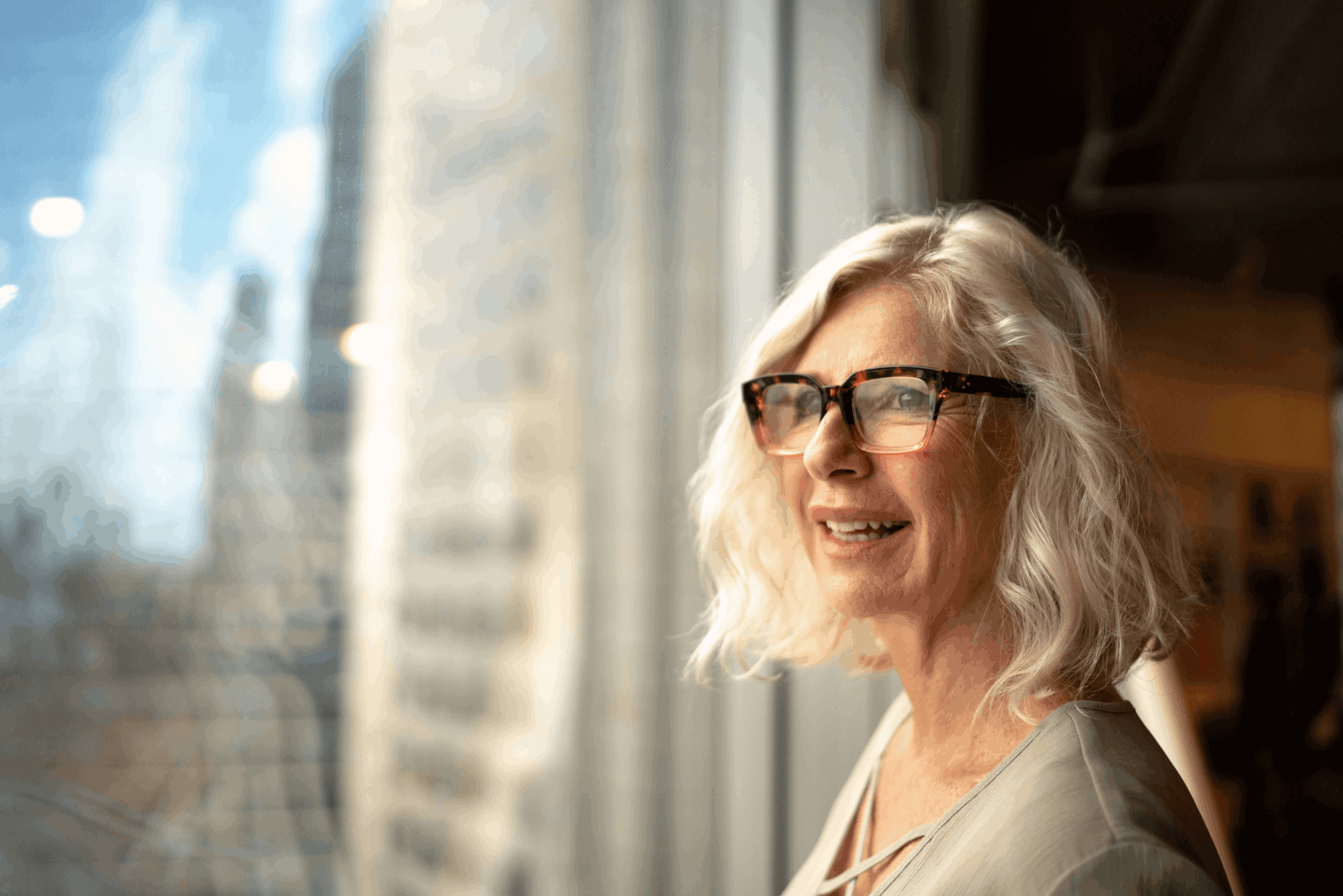 Older woman with glasses looking out the window