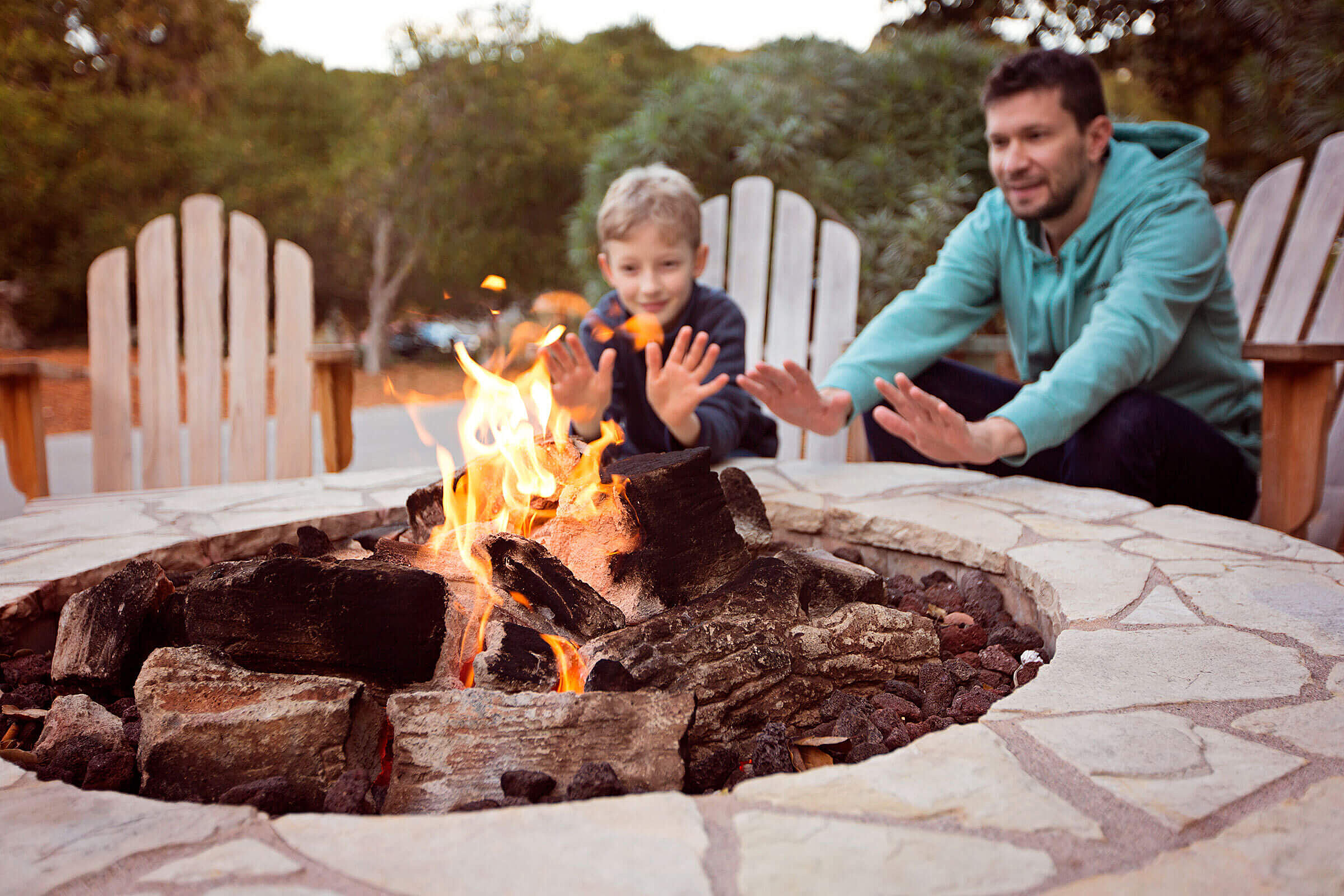 Father and son warming up hands on bonfire 1